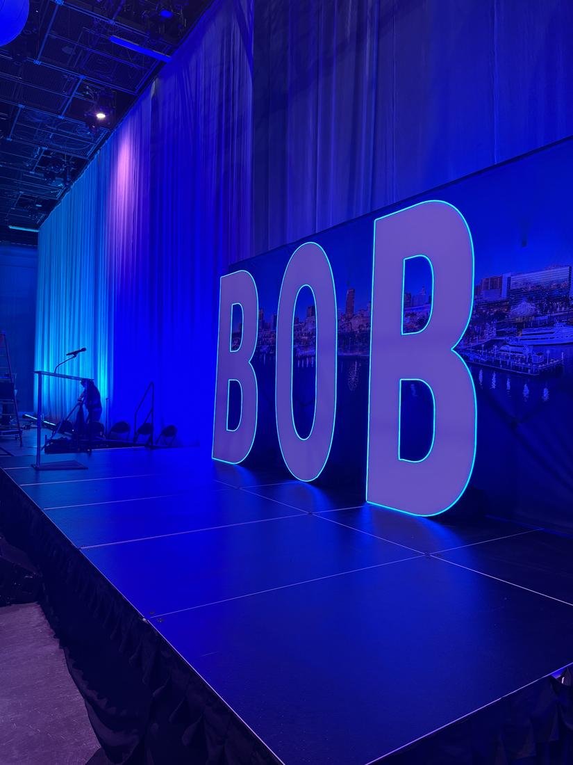 Giant white letters spelling BOB edged in blue LED on a stage