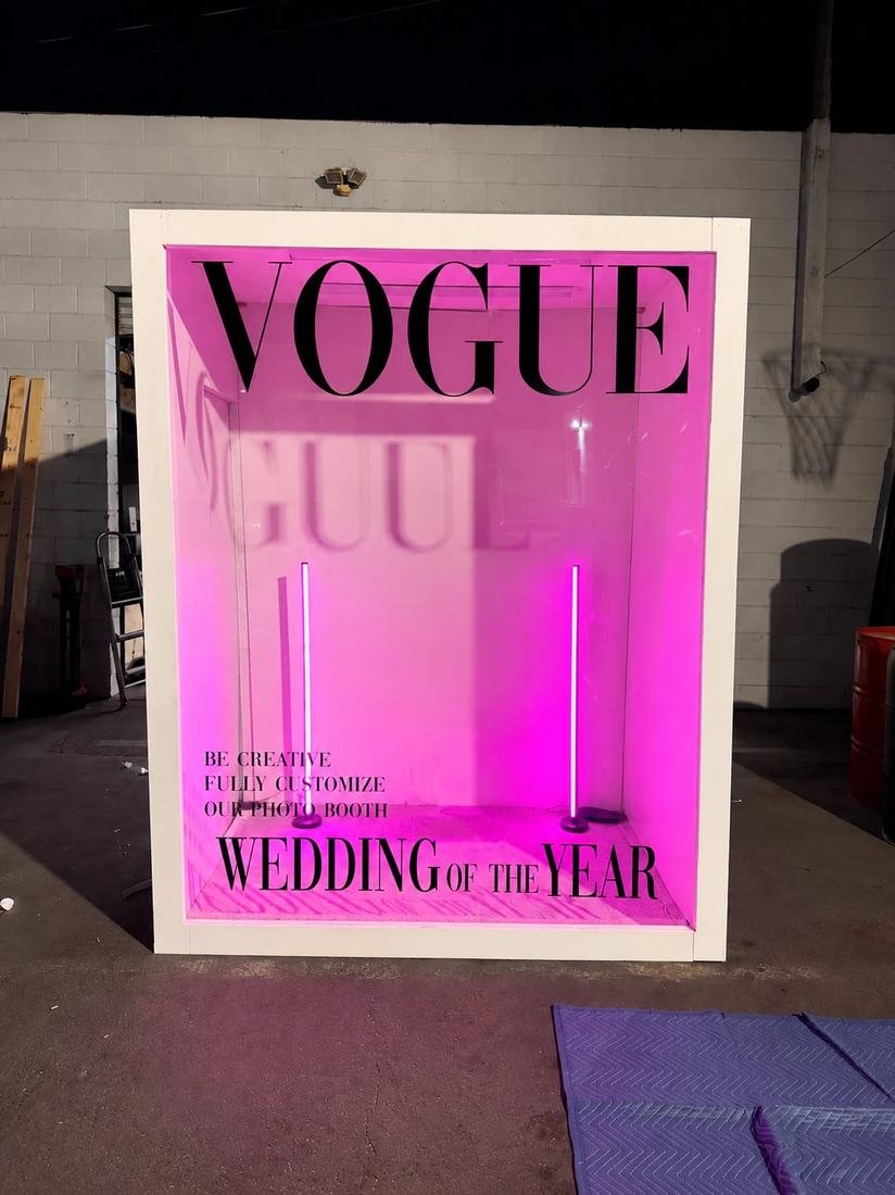 Custom photo booth lit in pink with a vinyl cover design