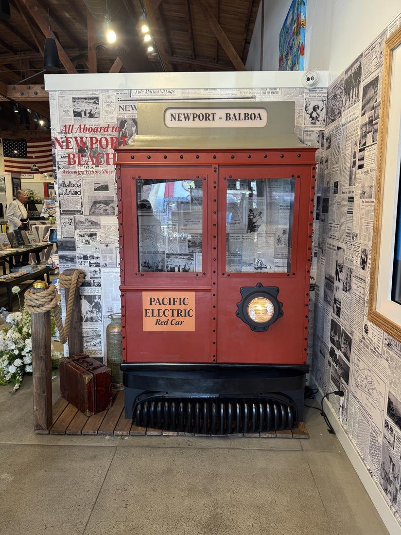 Hand built red streetcar photo prop with a lit headlight in front of a newspaper print wall